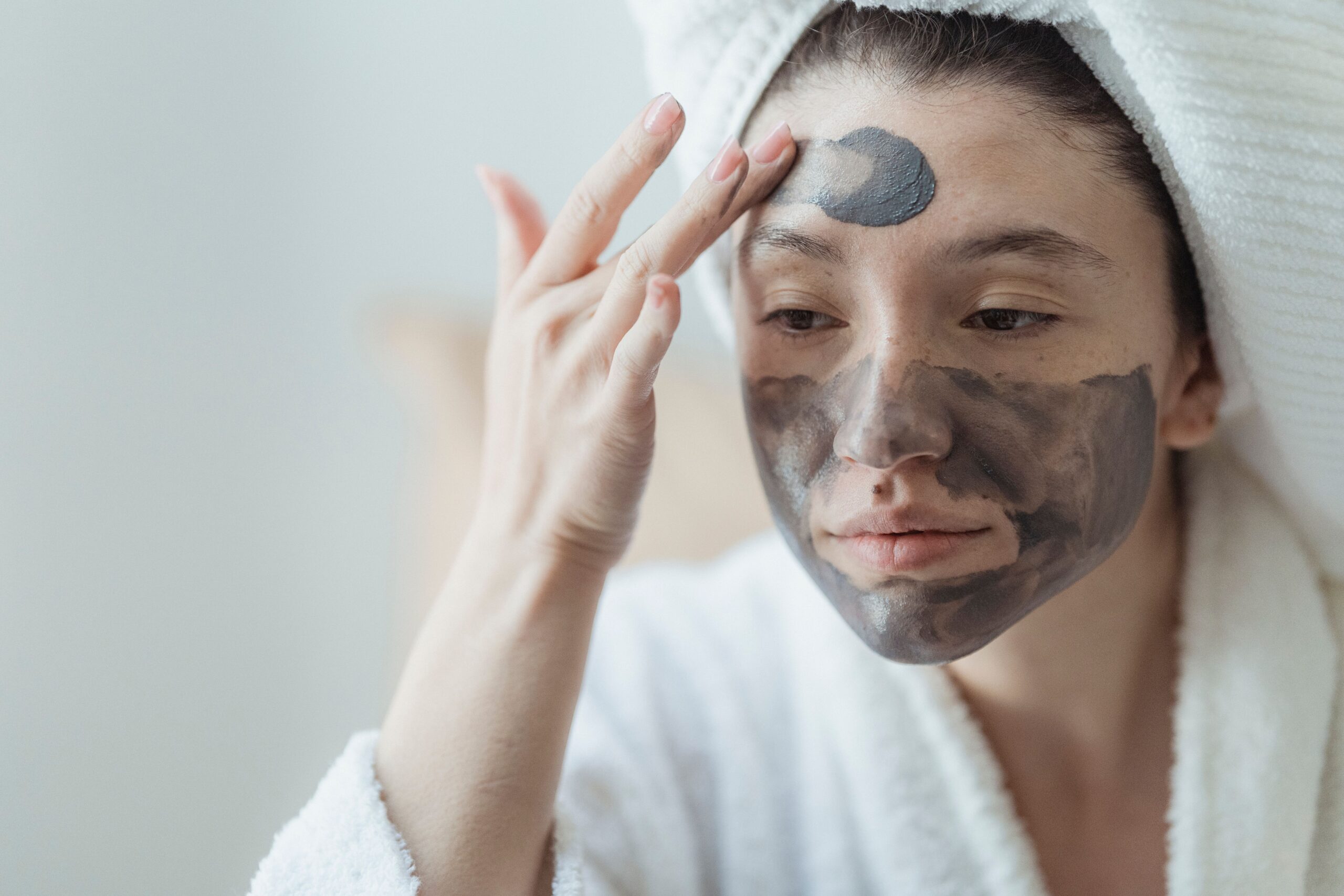 Close-up of a woman applying a facial mask to her skin